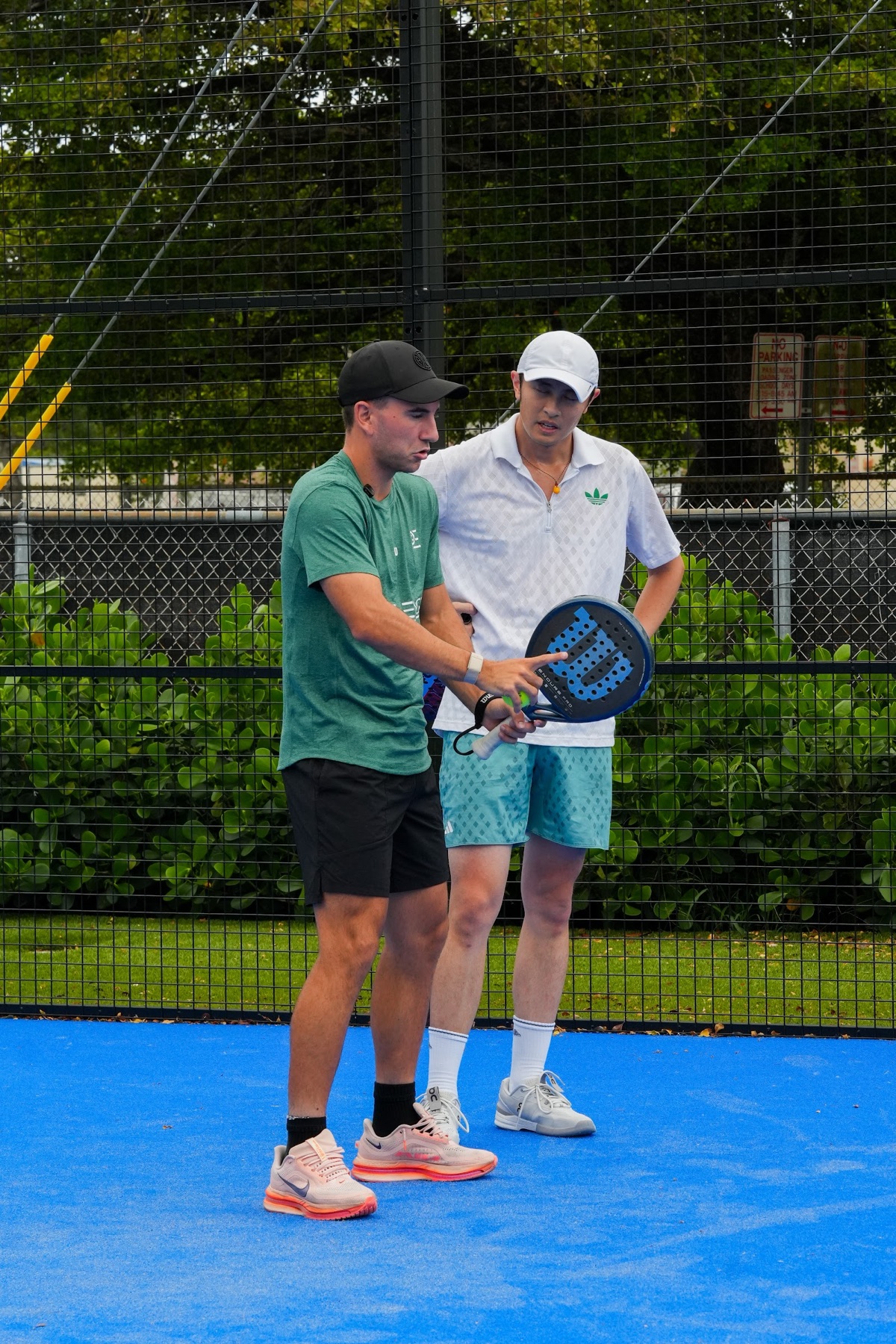A PadelEdge coach demonstrating racket technique to a player